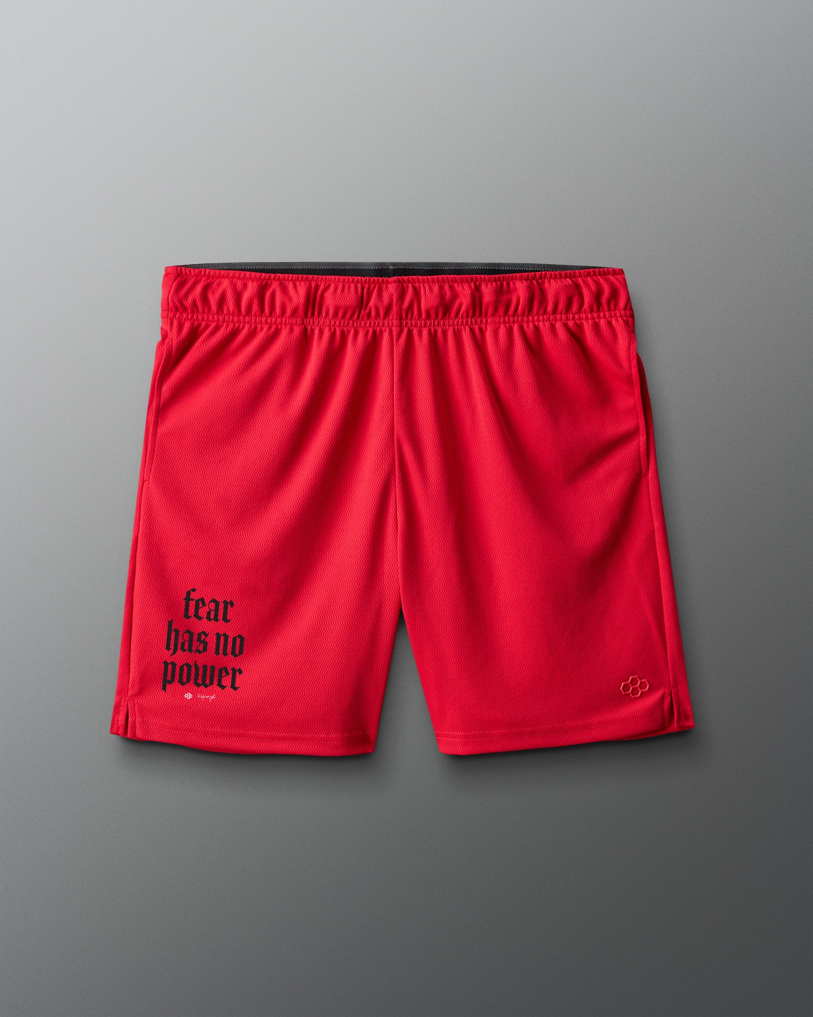 Red shorts with 'fear has no power' text on a gray background