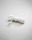 A neatly arranged bundle of white shoelaces with flat textured surface and plastic tips set against a soft gray background