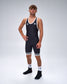 A man modeling a black athletic singlet with white trim, white socks, and black athletic shoes against a light gray studio background.