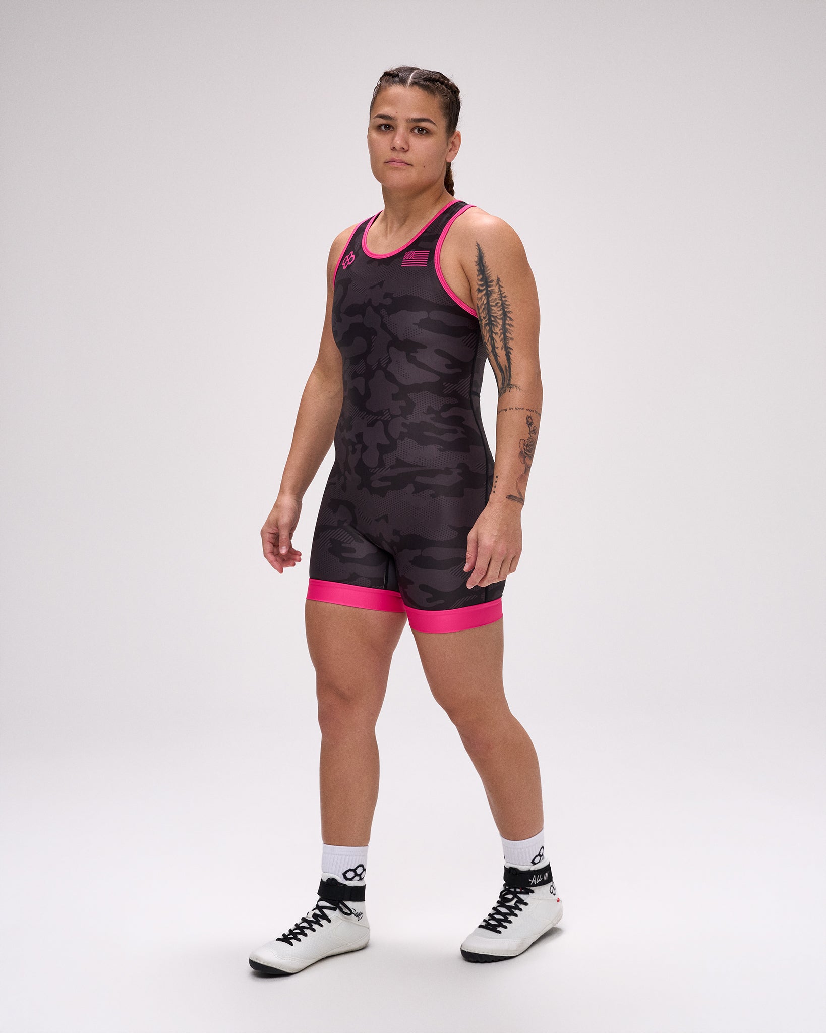 Person wearing a black and pink wrestling singlet on a white background
