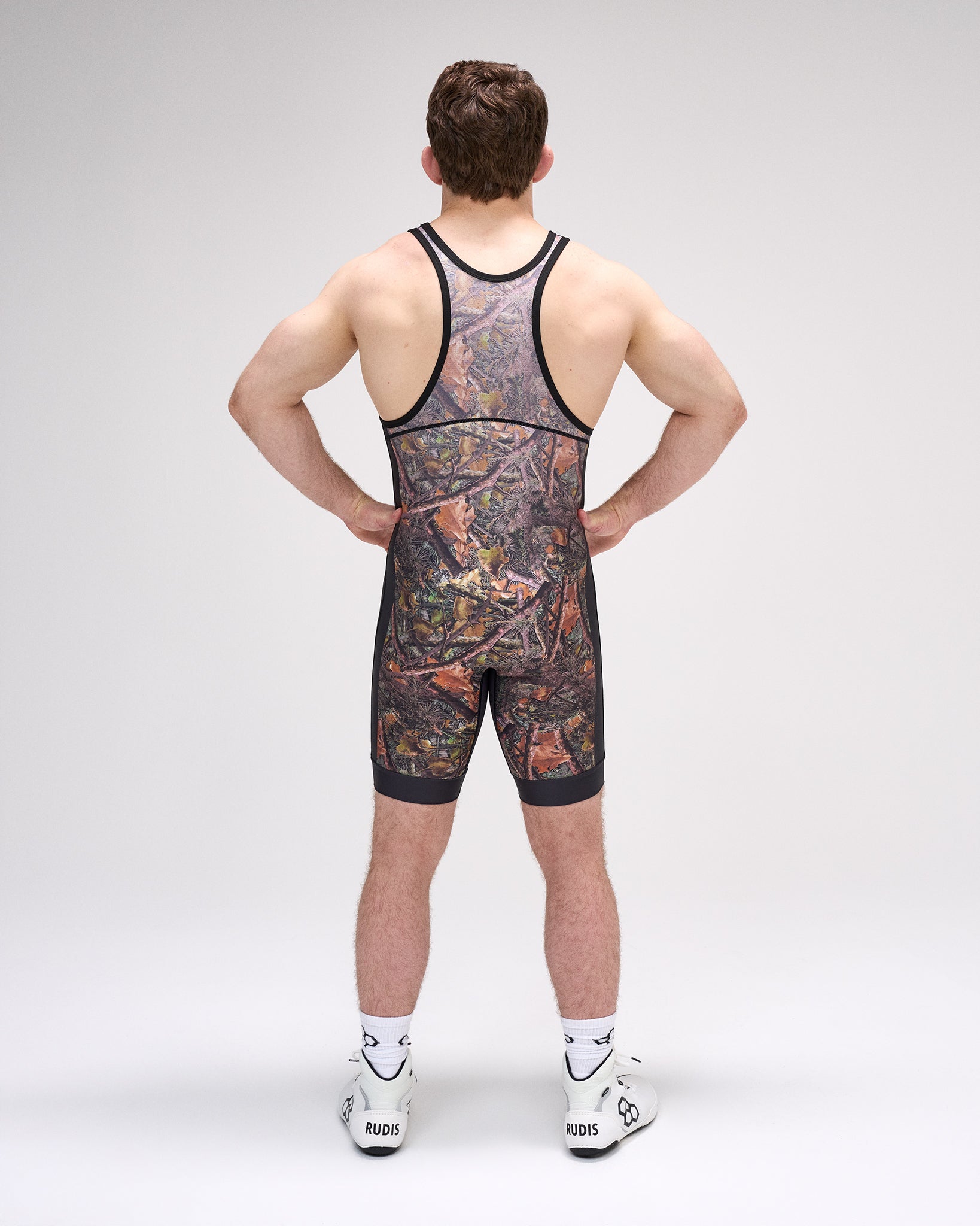 Person wearing a camouflage wrestling singlet on a plain background