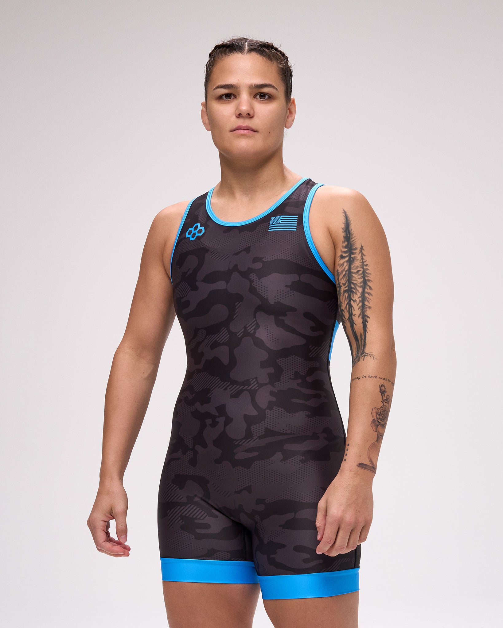 Person wearing a black and blue wrestling singlet on a gray background