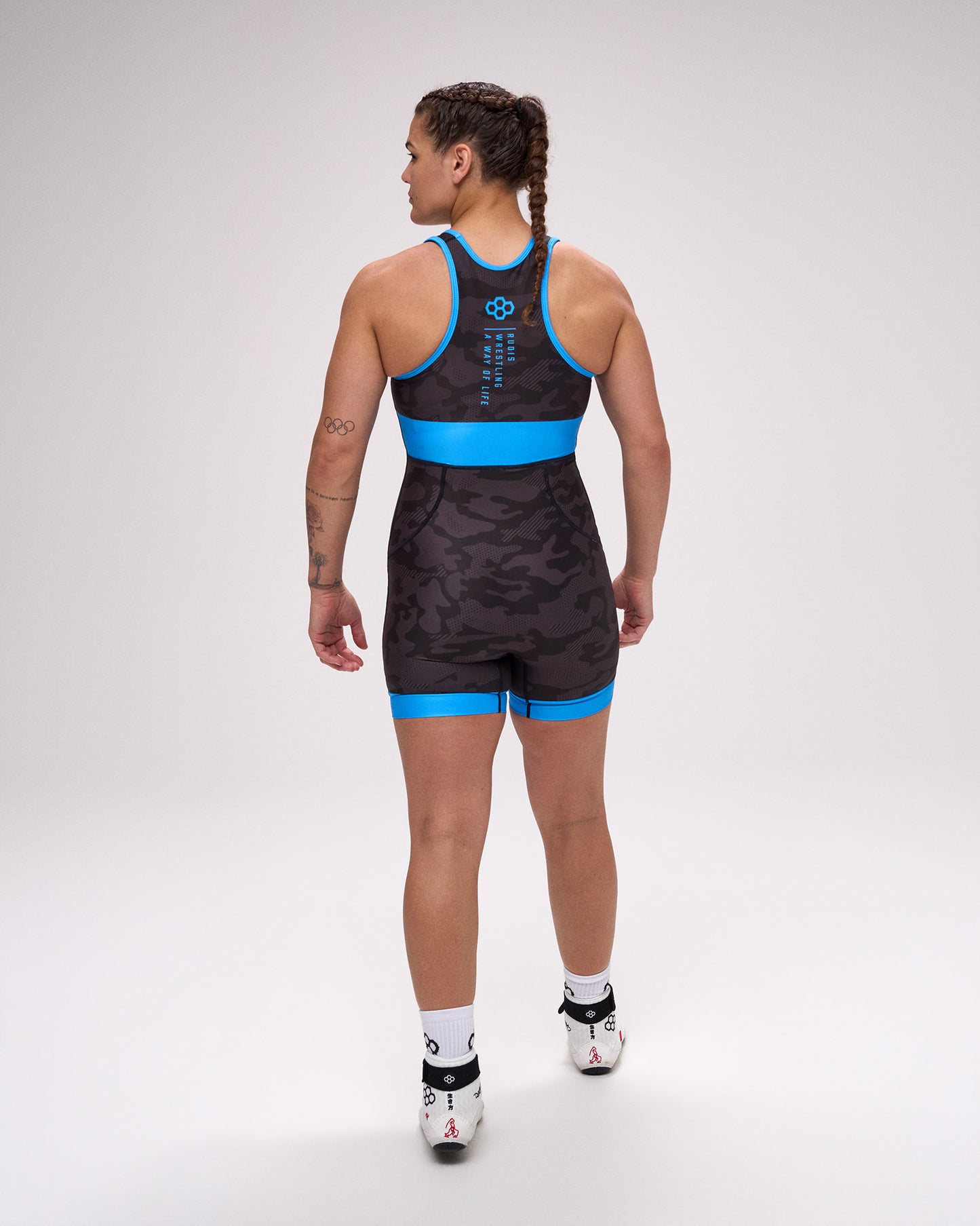 Person wearing a black and blue wrestling singlet on a white background