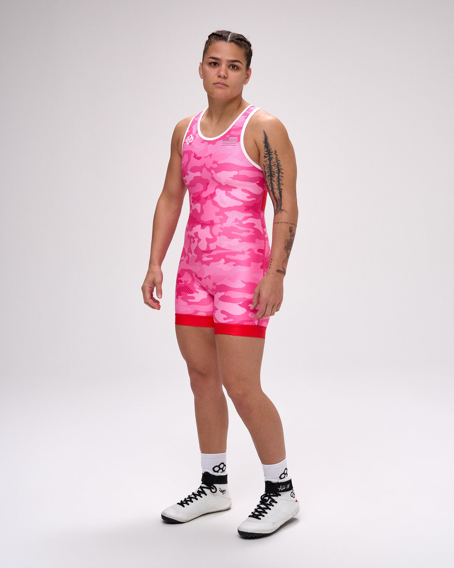 Person wearing a pink tie-dye wrestling singlet on a white background
