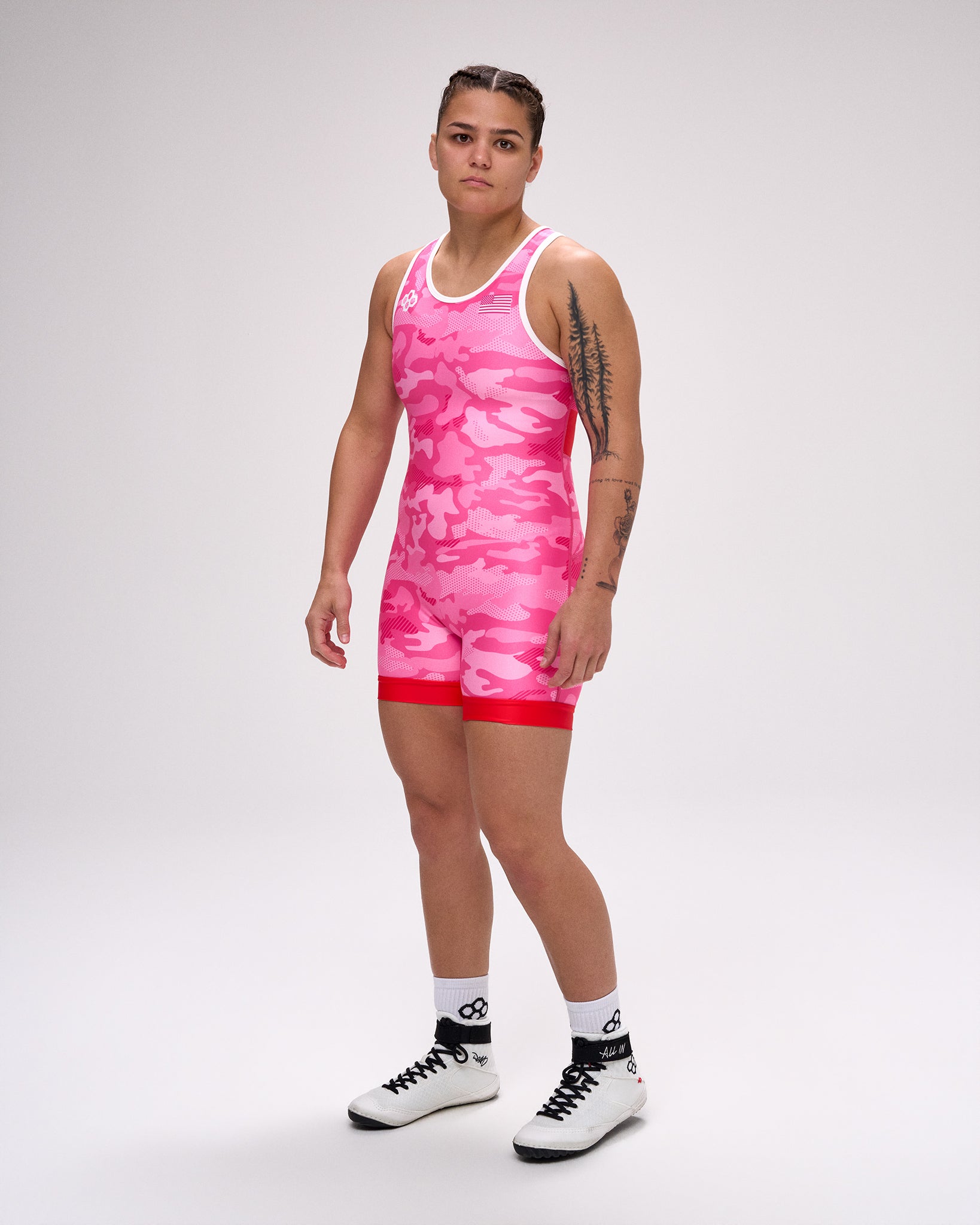 Person wearing a pink tie-dye wrestling singlet on a white background