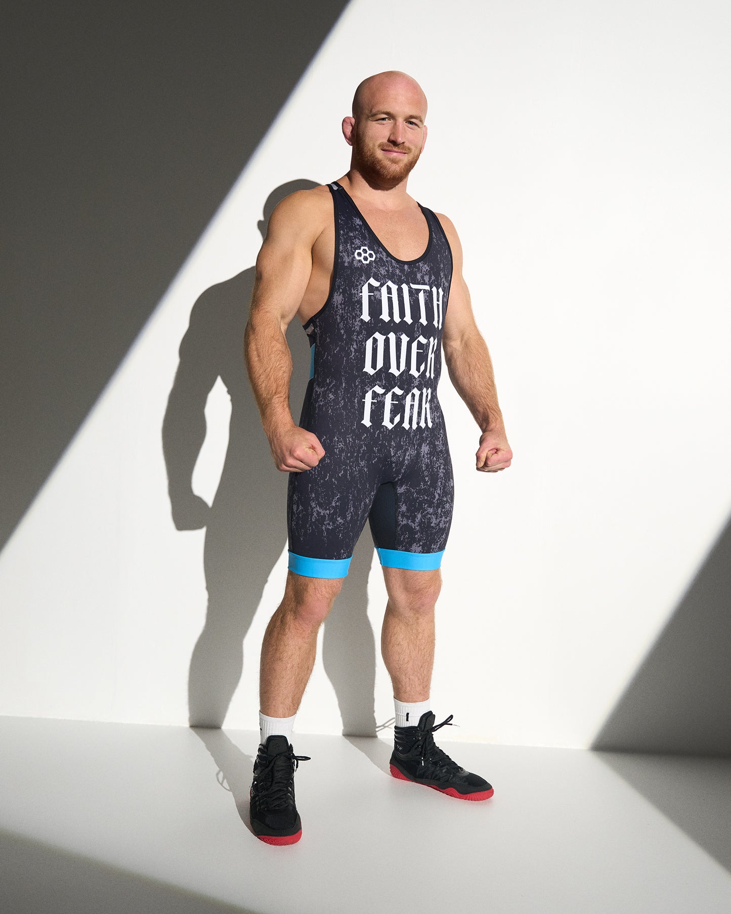 Athlete wearing the RUDIS Faith Over Fear Freestyle Elite 2.0 Wrestling Singlet in blue, featuring bold gothic "Faith Over Fear" graphics, lightweight performance fabric, and an elite competition fit.