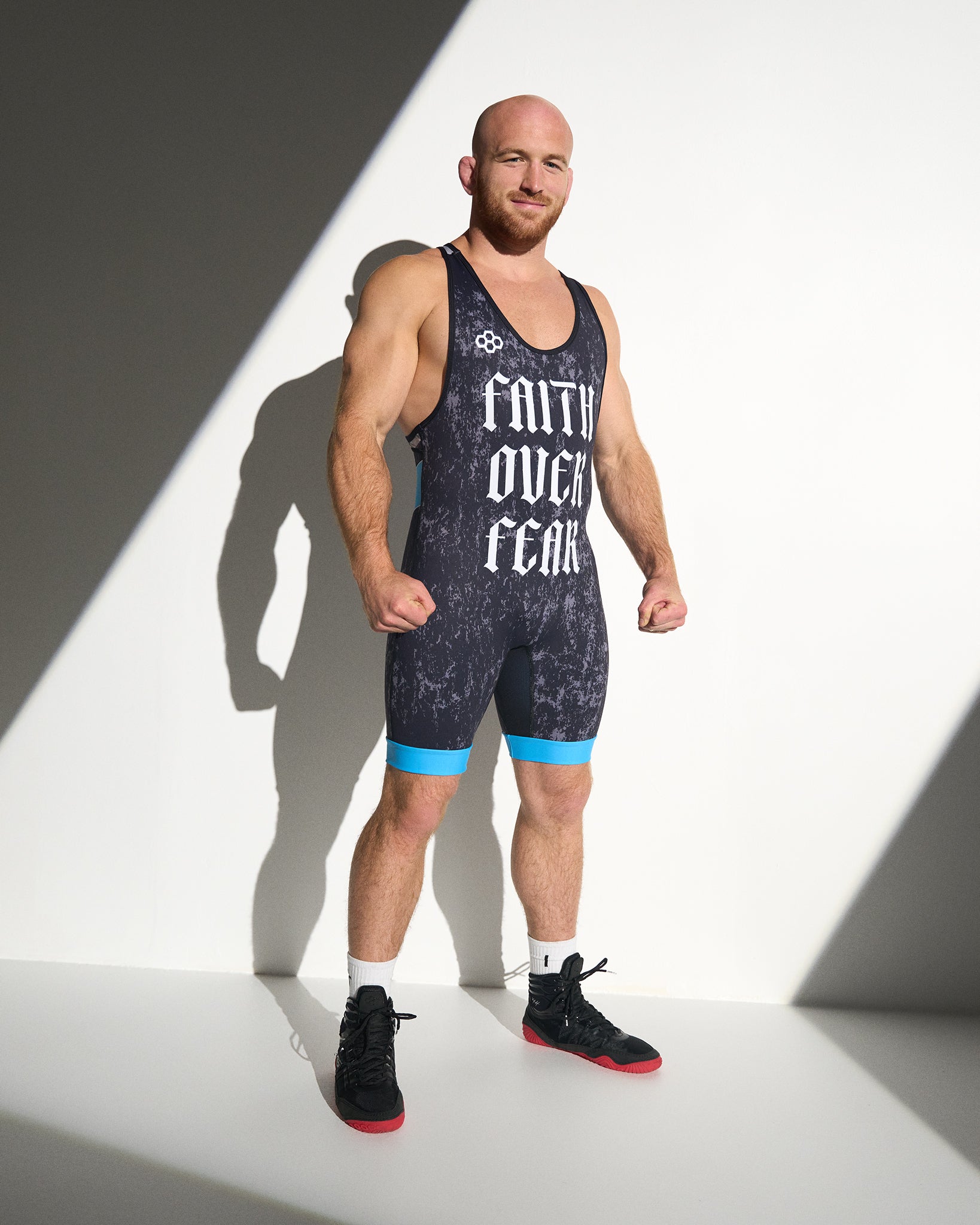Athlete wearing the RUDIS Faith Over Fear Freestyle Elite 2.0 Wrestling Singlet in blue, featuring bold gothic "Faith Over Fear" graphics, lightweight performance fabric, and an elite competition fit.