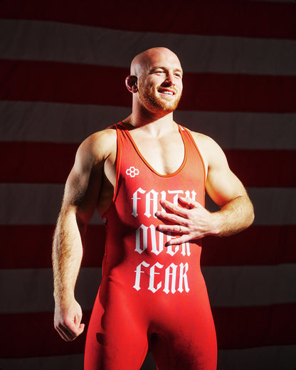 Athlete wearing the RUDIS Faith Over Fear Freestyle Elite 2.0 Wrestling Singlet in red, featuring bold gothic lettering and lightweight competition-ready performance fabric.