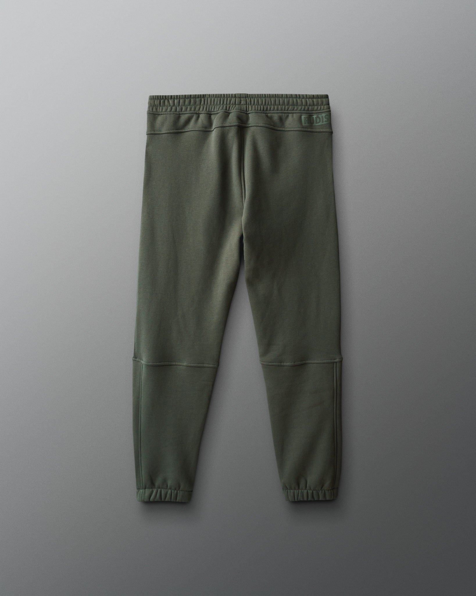 Green jogger pants on a gray background