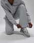 Person wearing a gray tracksuit with matching sneakers on a light gray background