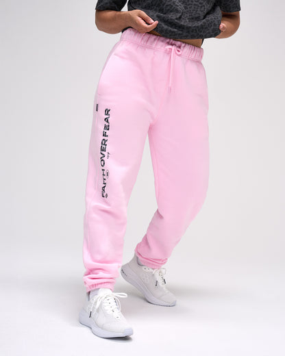 Pink sweatpants with 'Faith over fear' text on a white background