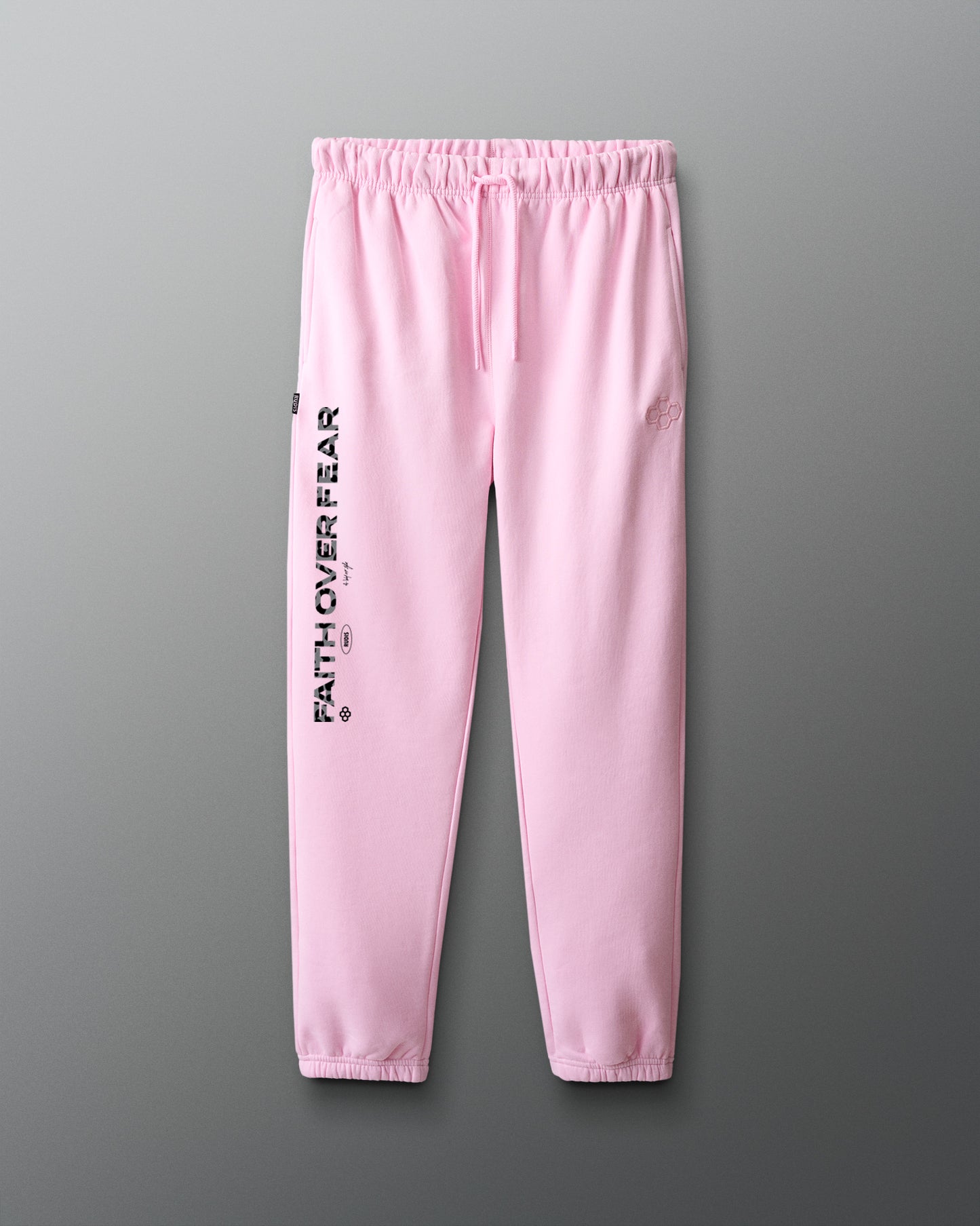 Pink sweatpants with 'Faith over fear' text on a gray background