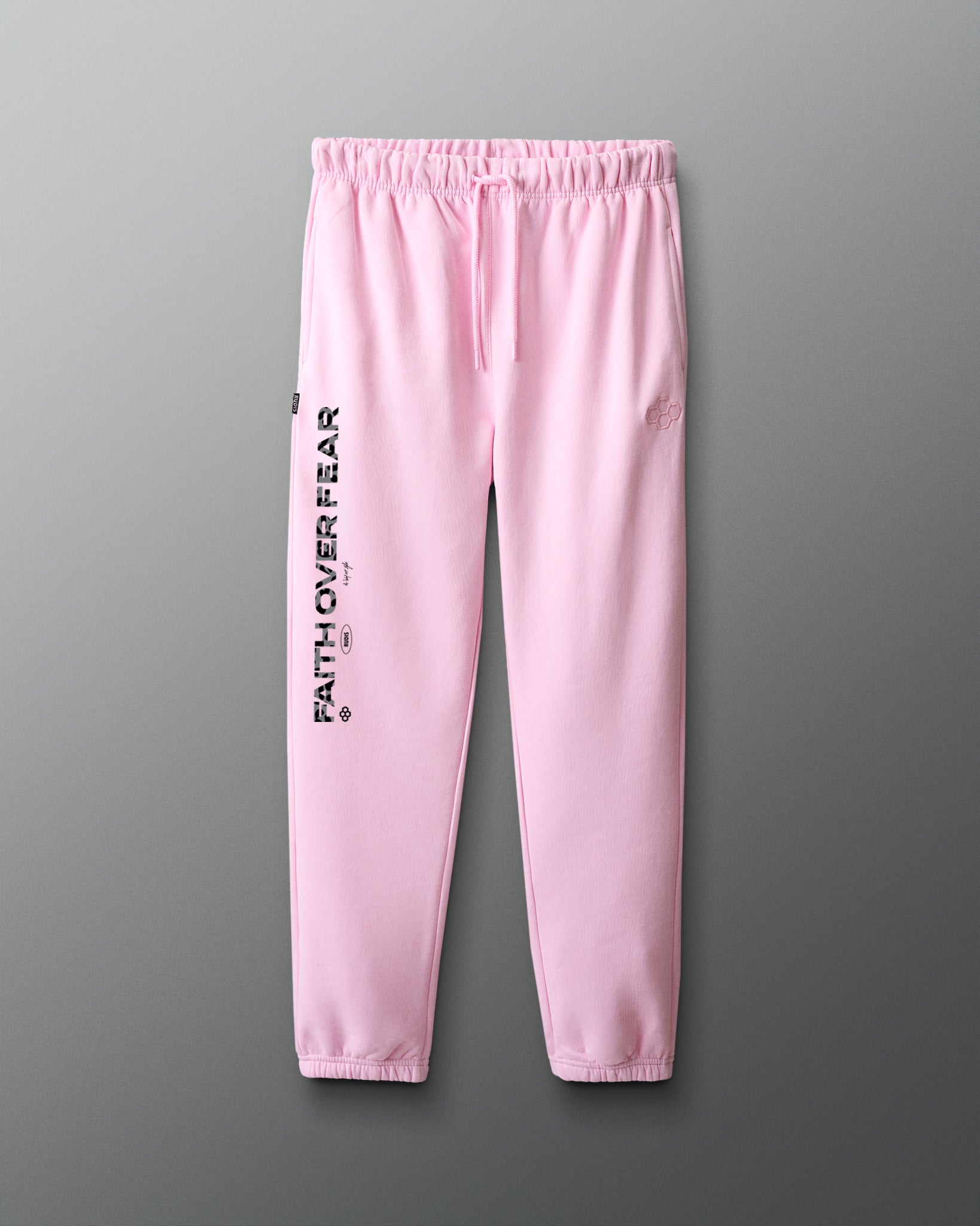 Pink sweatpants with 'Faith over fear' text on a gray background