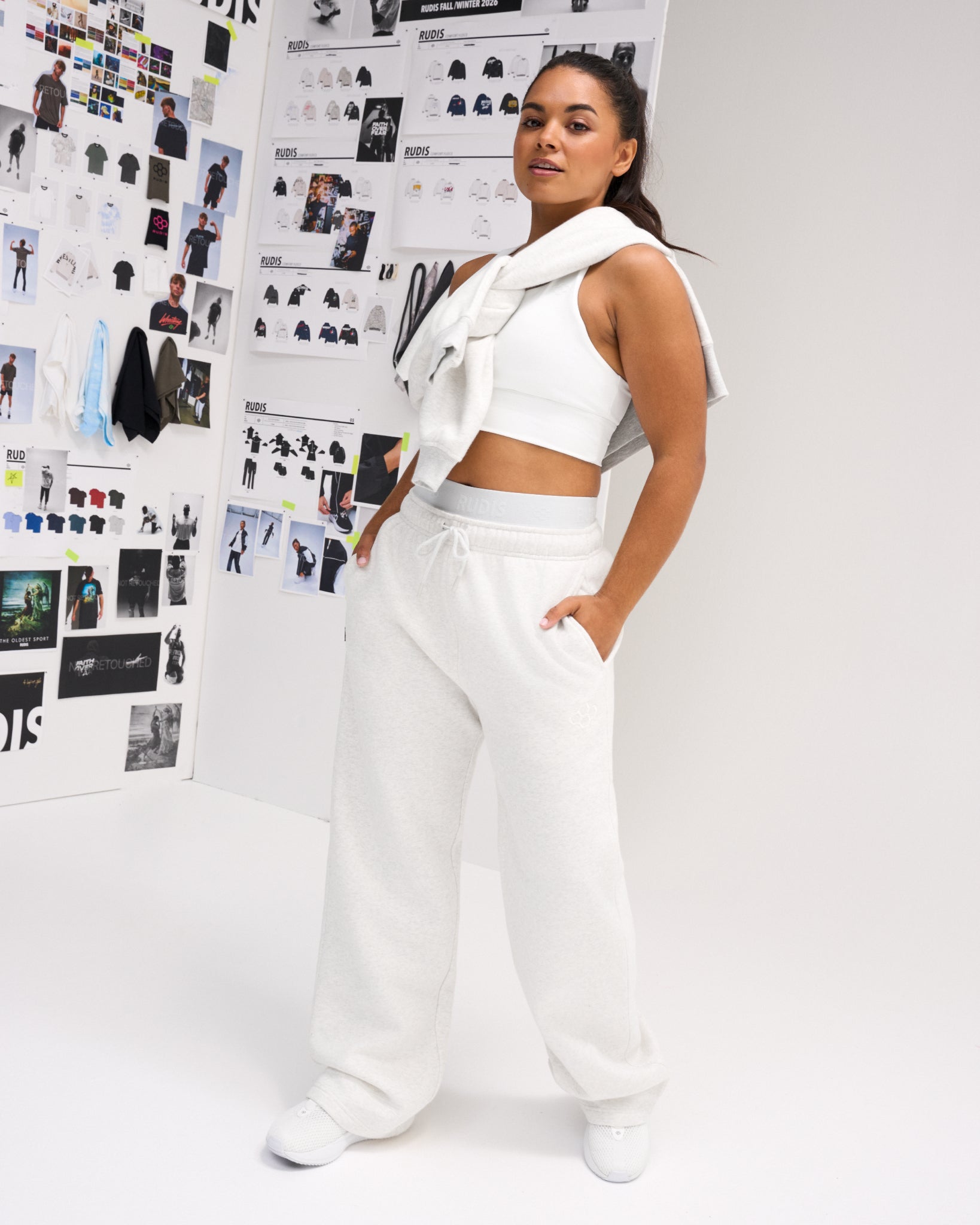 Female model wearing RUDIS Comfort Fleece Wide Leg Sweatpants in Heather Silver, highlighting the wide-leg fit, elastic drawstring waistband and side pockets.