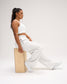 Side view of a seated model wearing RUDIS Comfort Fleece Wide Leg Sweatpants in Heather Silver, featuring a relaxed wide-leg fit, branded waistband and soft fleece fabric.