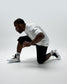 Side view of RUDIS Titan Heavyweight Cut Off Sweatpants in black worn by a wrestler in a low kneeling stance.
