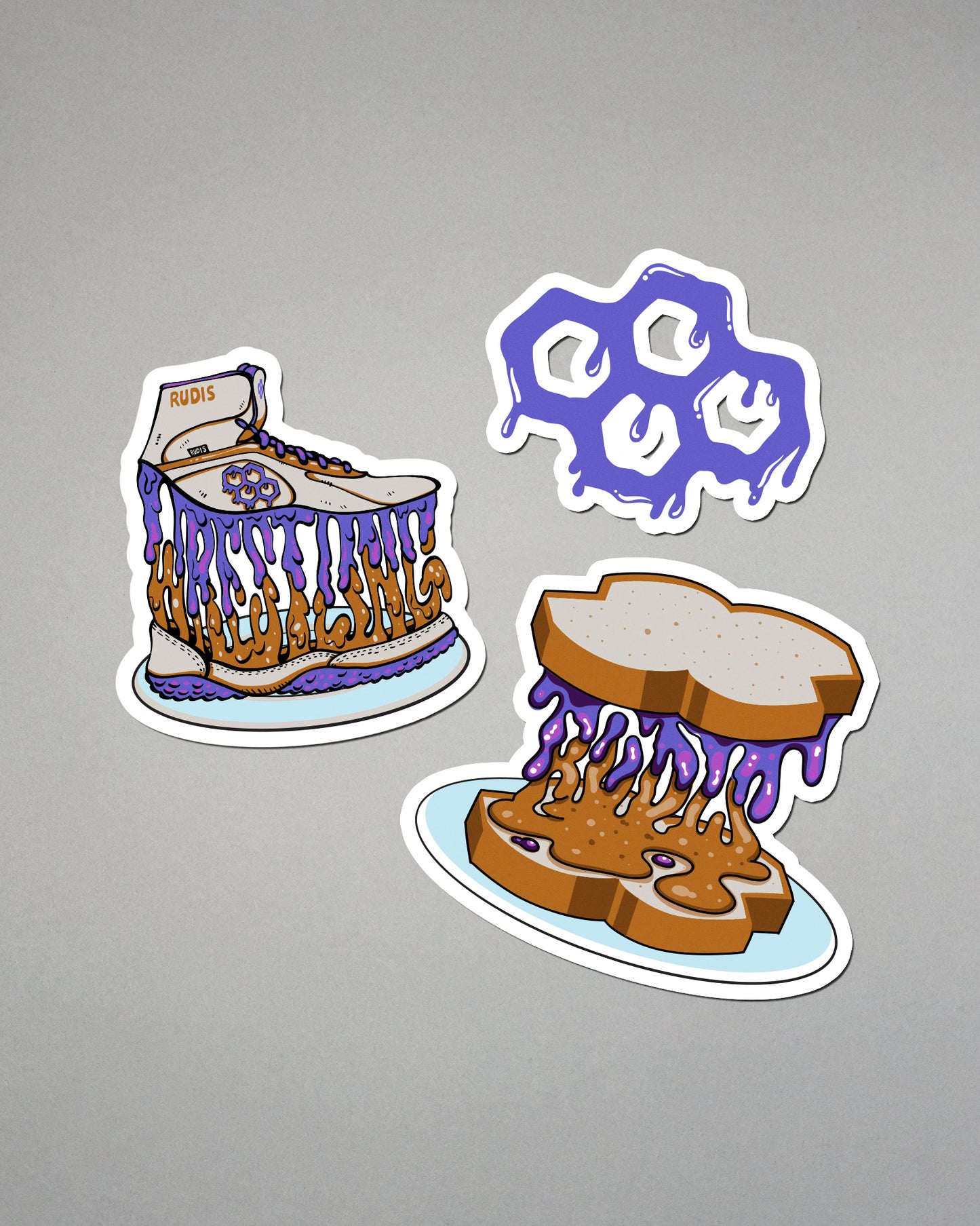 Three cartoon-style stickers of a cake, a skull, and a sandwich with purple sauce on a gray background.