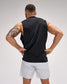 Man wearing a black sleeveless shirt and light gray shorts on a plain background