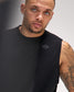 Man wearing a black sleeveless shirt with a logo on a gray background
