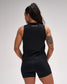 Person wearing a black sleeveless top and shorts set on a gray background