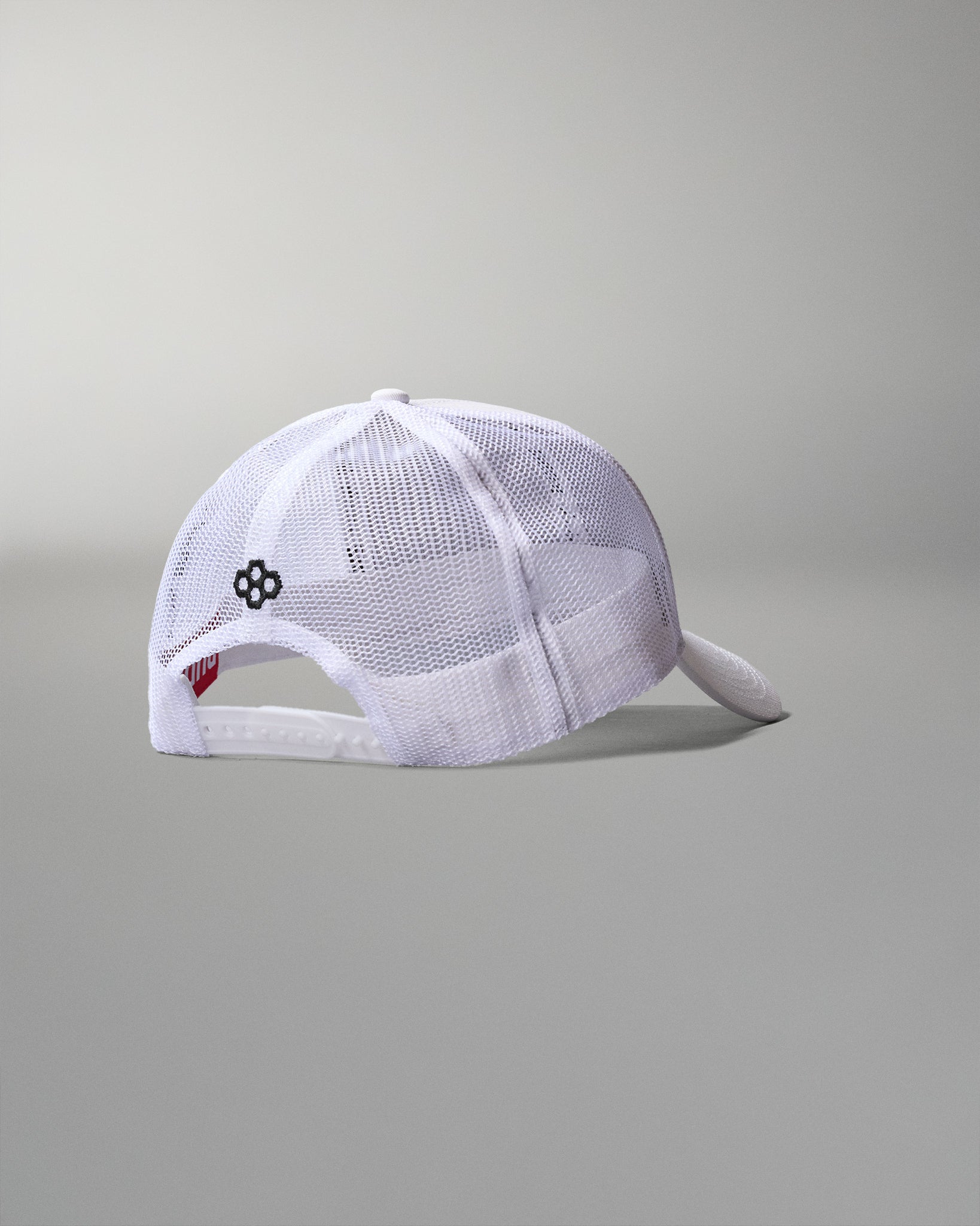 White mesh cap with a small logo on a gray background