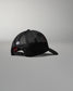 Rear angled view of the RUDIS Fearless Faith Bridge Trucker Hat in Black, showcasing breathable mesh panels, adjustable snapback closure and white embroidered RUDIS emblem.