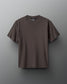 A dark olive green t-shirt with a round neckline is set against a textured gray background, featuring the brand 'RUDIS' on the inside label, creating a modern and minimalist presentation.