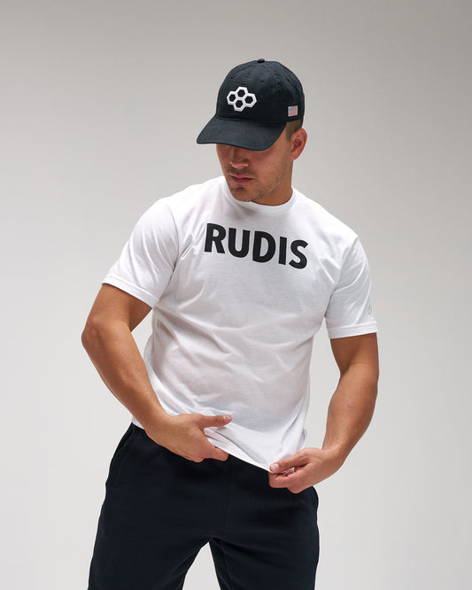 Person wearing a white t-shirt with 'RUDIS' text and a black cap on a gray background