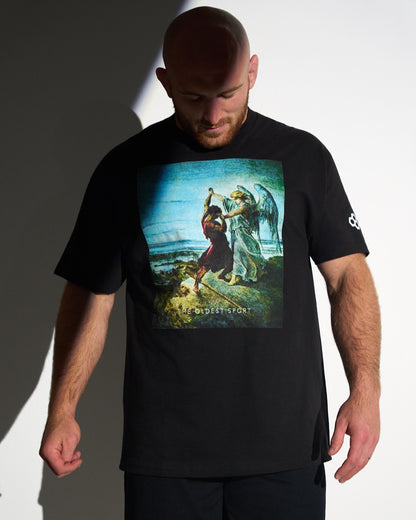 Man wearing a black t-shirt with a graphic design on a plain background