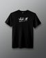 Front view of a black T-shirt with the phrase ‘ALL IN’ printed in bold white handwritten-style lettering across the chest, with an underline.