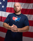 Athlete wearing the RUDIS USA Wrestling T-Shirt in navy featuring a bold USA wrestling map graphic, standing in front of an American flag.