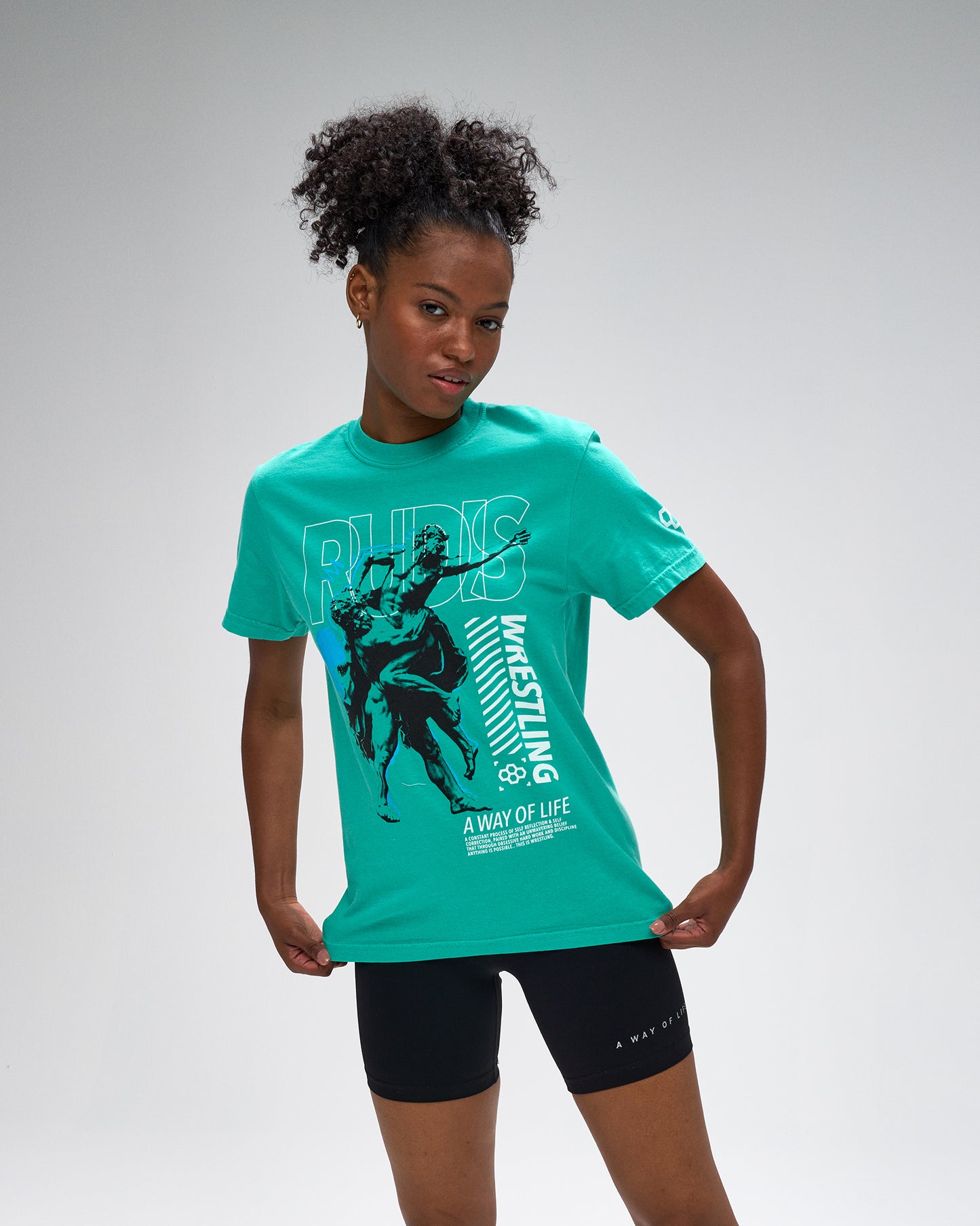 Person wearing a green t-shirt with graphic design on a gray background