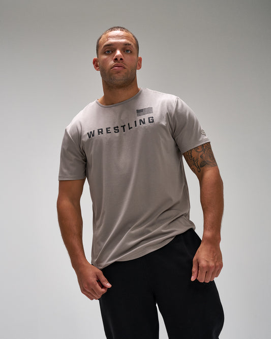 Man wearing a gray 'Wrestling' t-shirt on a plain background