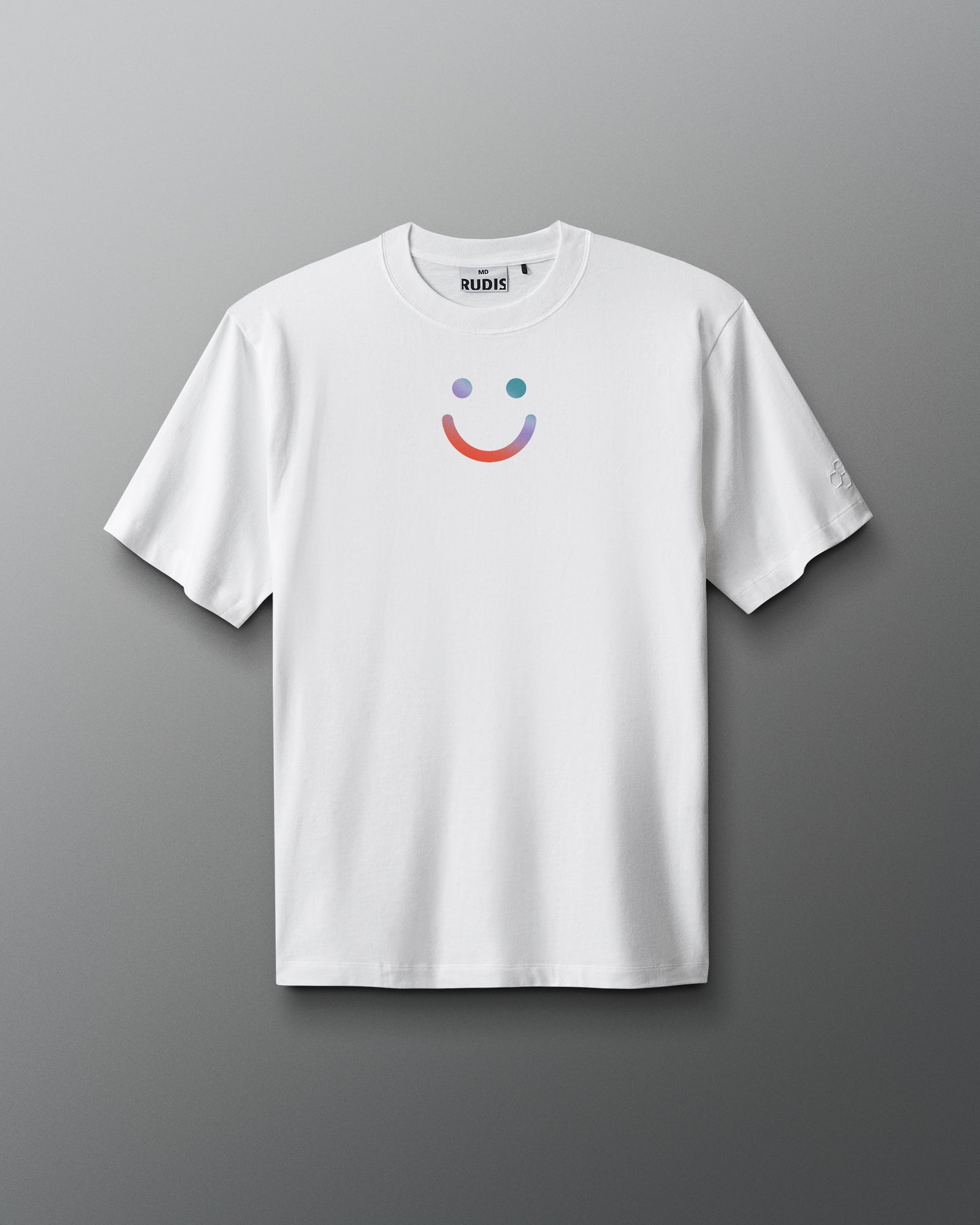 White t-shirt with a colorful smiley face design on a gray background. Sarah Hildebrandt