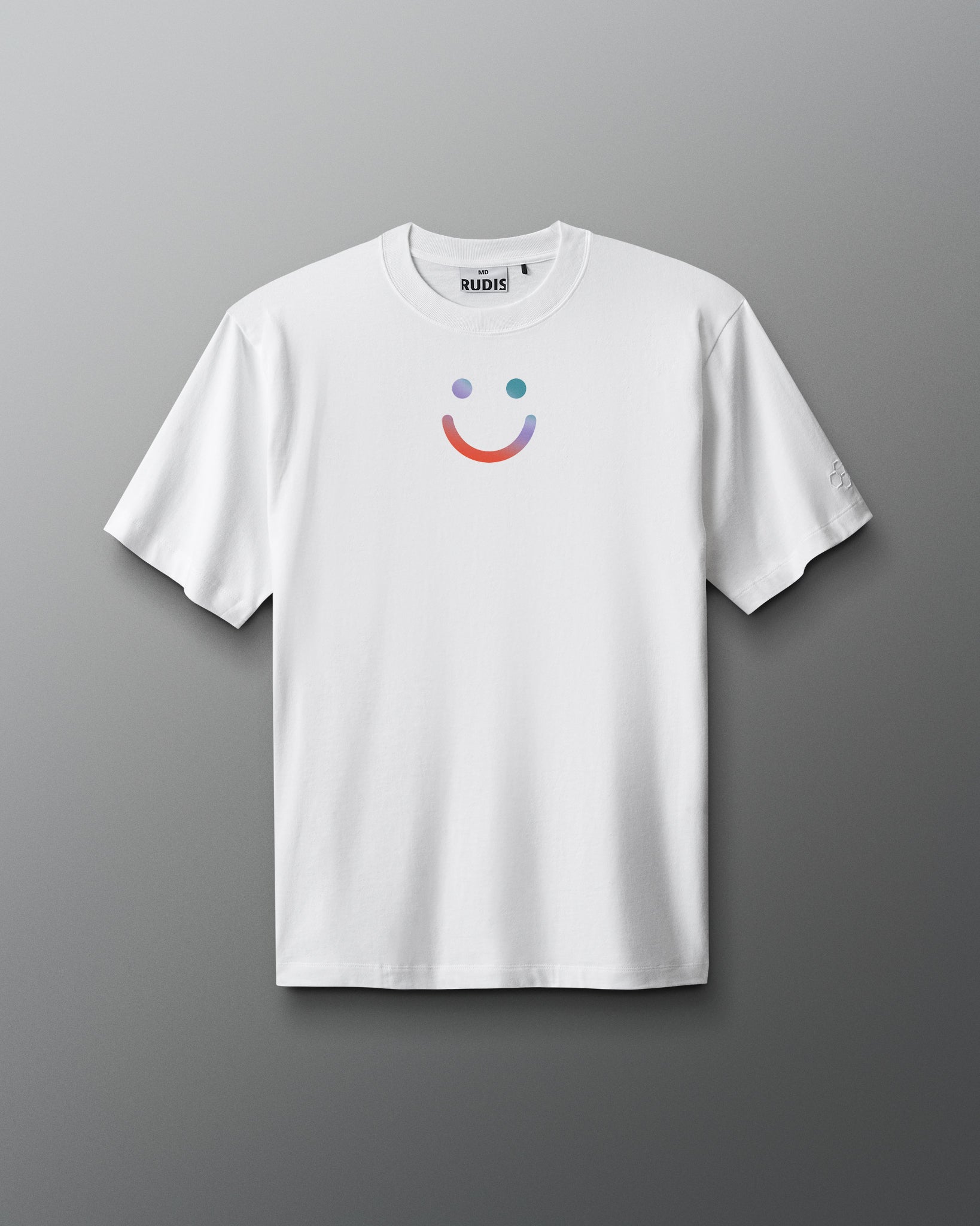 White t-shirt with a colorful smiley face design on a gray background. Sarah Hildebrandt