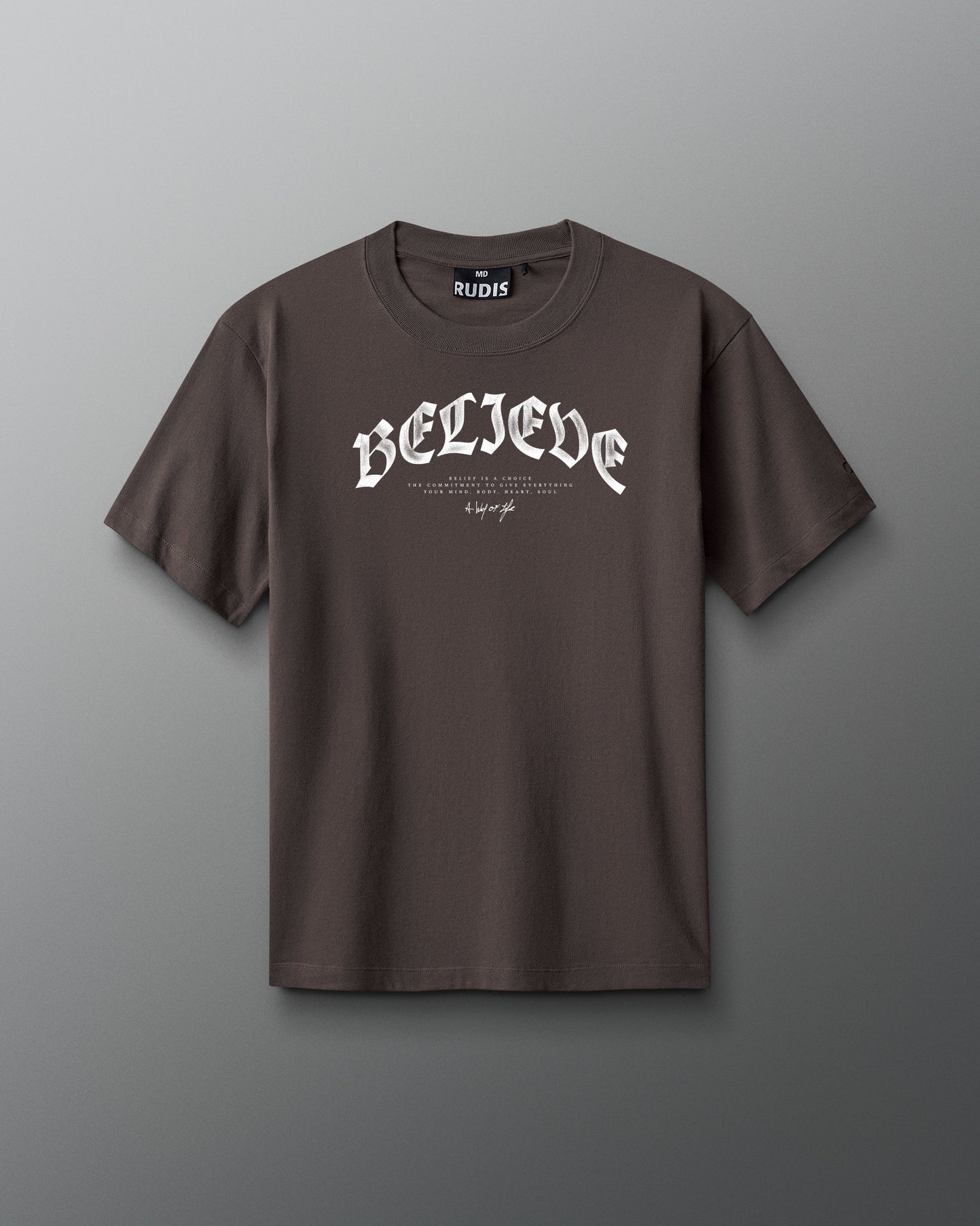 Brown t-shirt with 'BELIEVE' text on a gray background