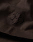 Close-up of a black embroidered design on a dark fabric surface