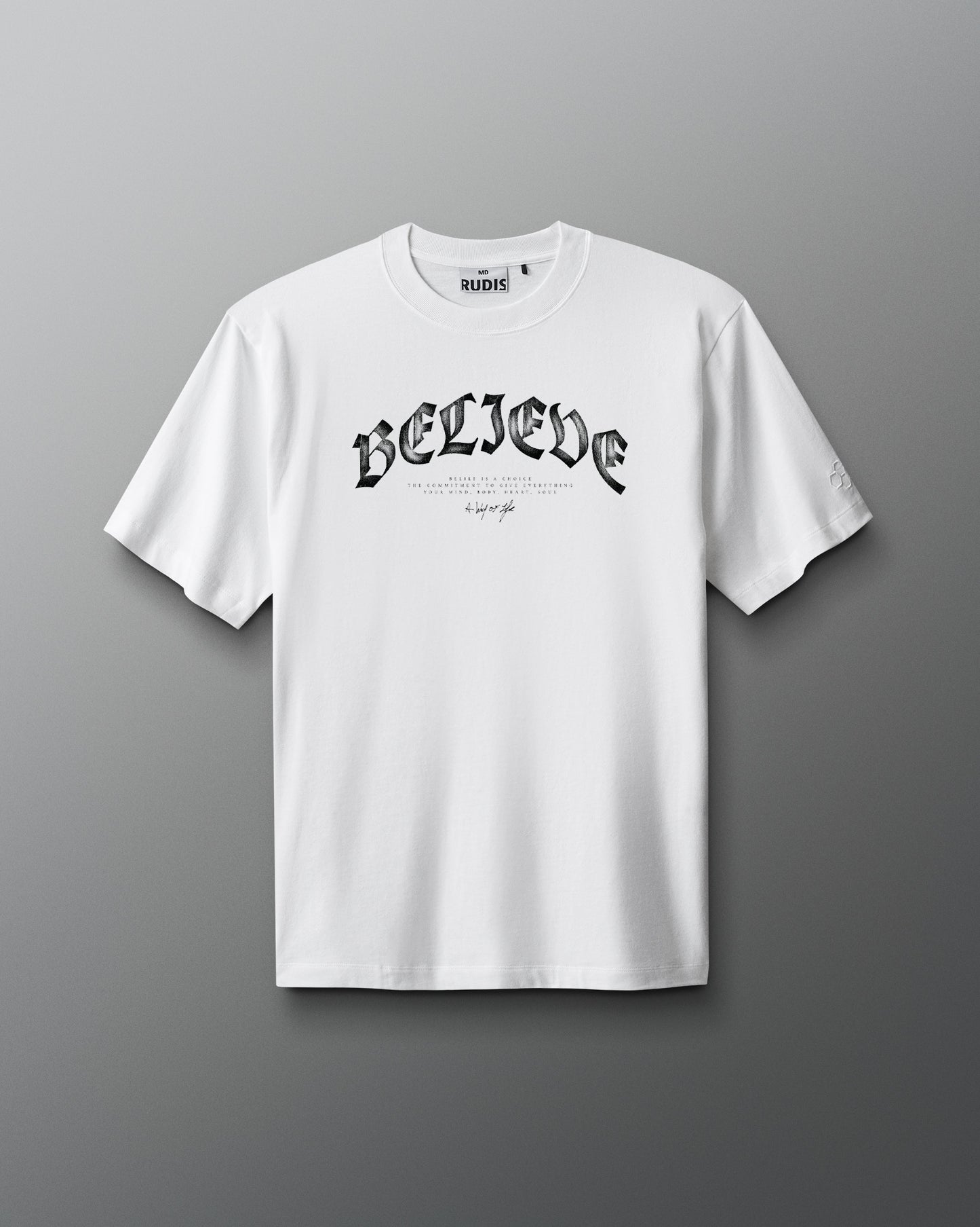 White t-shirt with 'BELIEVE' text on a gray background