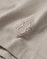 Close-up of beige fabric with a quadhex hexagonal logo.