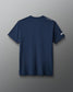Navy blue t-shirt with a brand logo on the back against a gray background