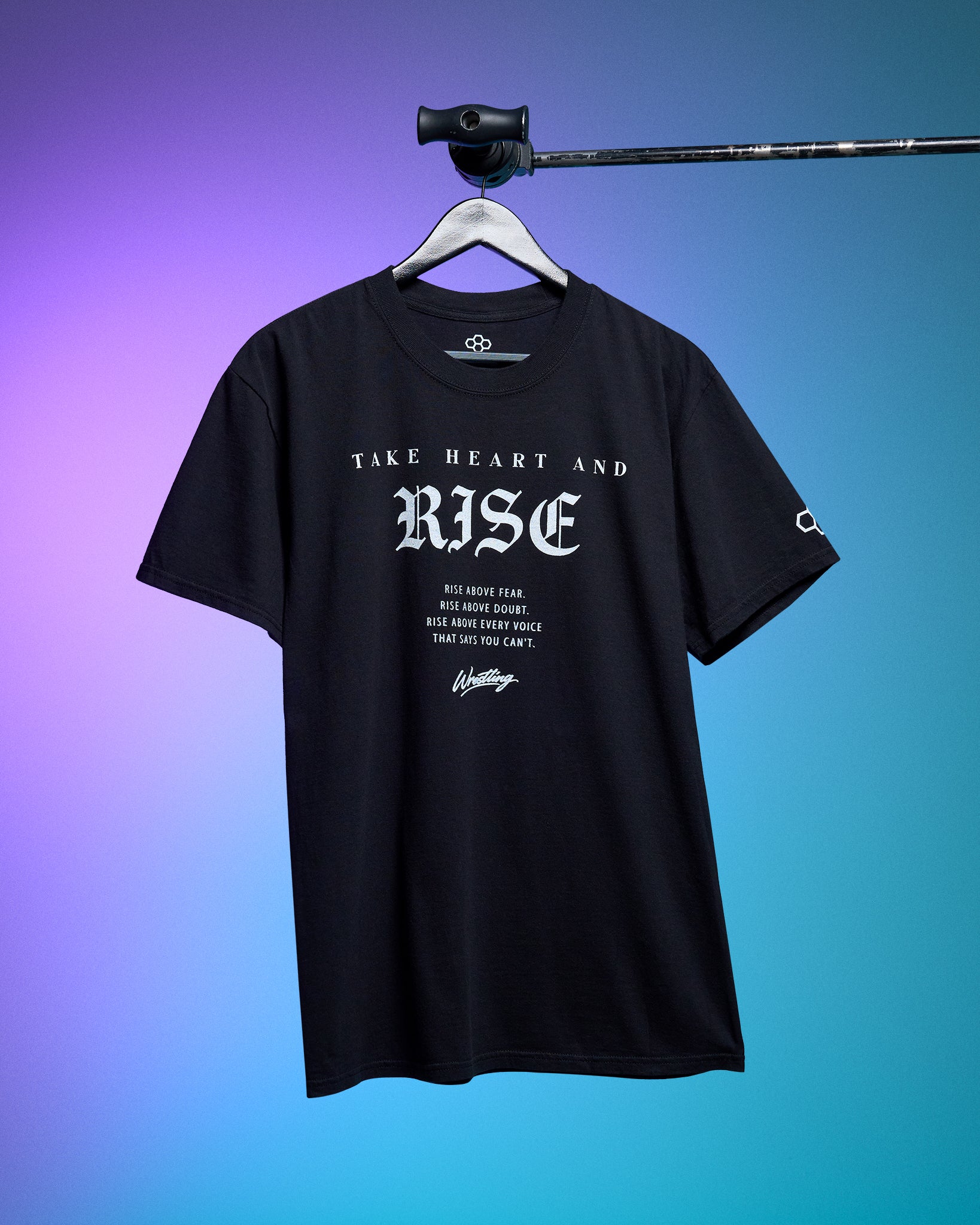 Black t-shirt with 'Take Heart and Rise' text on a hanger against a gradient background