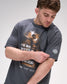 Man wearing a dark gray t-shirt with graphic design and "For we wrestle not against flesh and blood' text on a light gray background