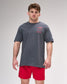 Man wearing a gray t-shirt with red text and red shorts on a gray background