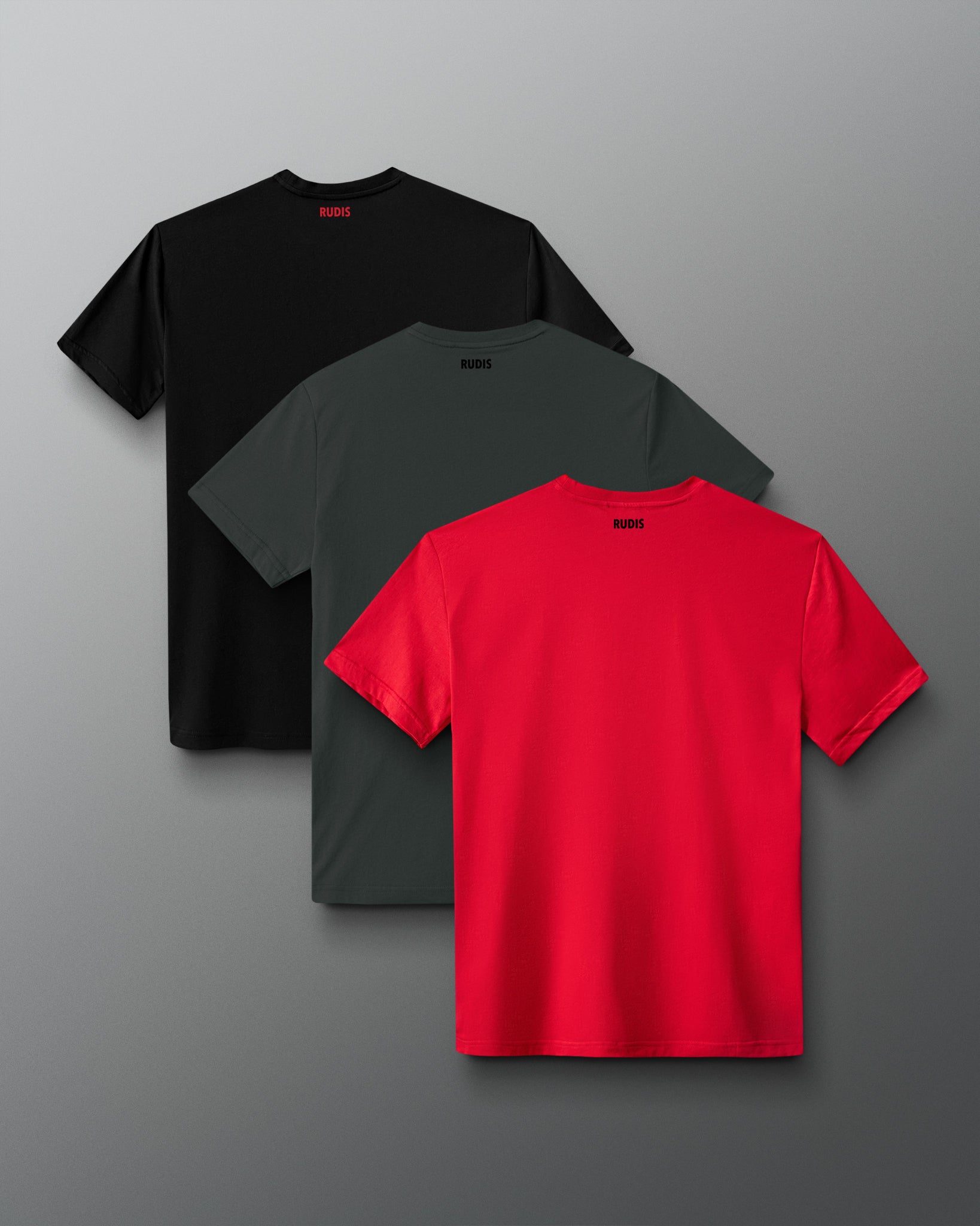 Three short-sleeve crew-neck T-shirts arranged in a fan layout on a gray gradient background: one black, one dark gray, and one bright red, each with a small black logo printed inside the back collar.