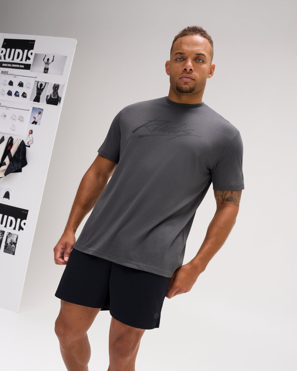 Model wearing the charcoal and black RUDIS Script Elite Super Soft T-Shirt with tonal RUDIS script graphics across the chest.