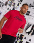 Model wearing the red and black RUDIS Script Elite Super Soft T-Shirt with bold black RUDIS script graphics across the chest.