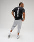 Back view of a model wearing the RUDIS Iron Sharpens Iron Classic Cotton T-Shirt in Washed Black, featuring a bold vertical white Iron Sharpens Iron graphic and classic short sleeves.