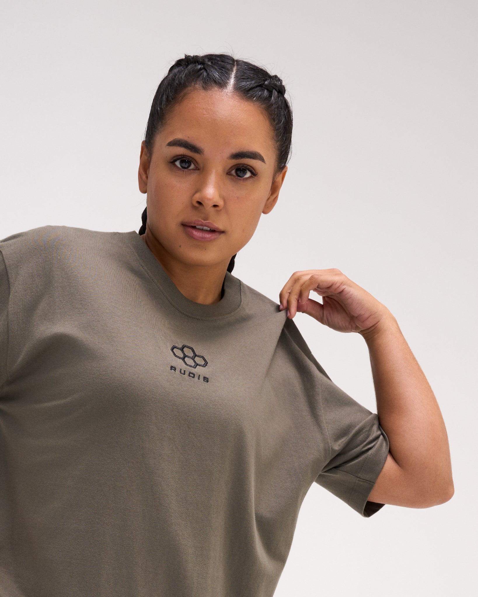 Close-up of a female model wearing the RUDIS Hex Classic Cotton T-Shirt in Army, highlighting the black embroidered chest logo and crew neckline.