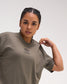 Close-up of a female model wearing the RUDIS Hex Classic Cotton T-Shirt in Army, highlighting the black embroidered chest logo and crew neckline.