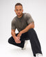 Male model crouching in the RUDIS Hex Classic Cotton T-Shirt in Army, showing the centered black Hex logo, short sleeves and relaxed silhouette.
